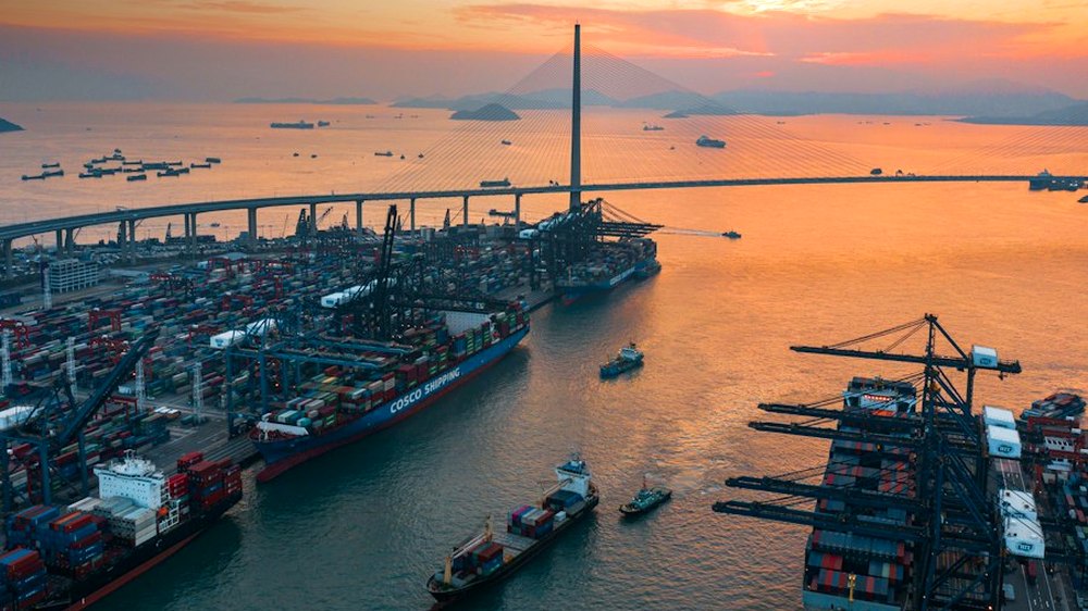A container terminal at dusk, with ships working alongside the quay.