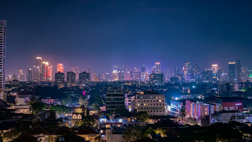 An ASEAN capital city at night, seen from the hills.